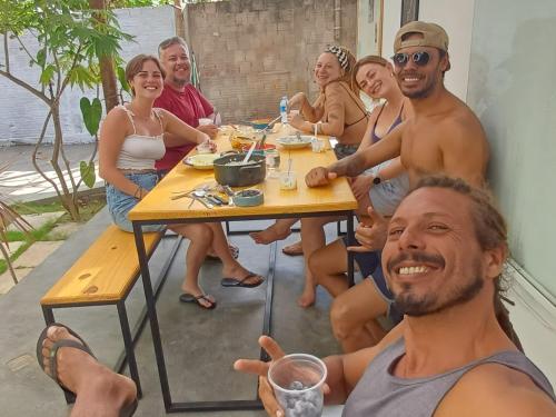 a group of people sitting around a table at Pipa Roots Hostel in Pipa