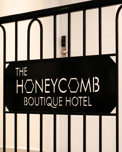 a sign for the honeycomb boutique hotel on a fence at The Honeycomb Boutique Hotel in Golem