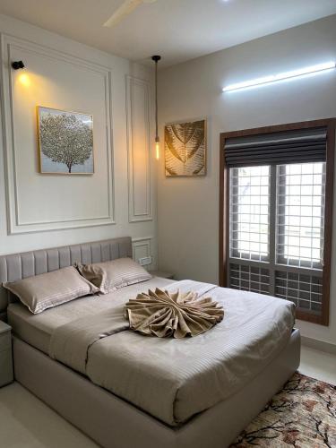 a bedroom with a large bed with a pillow on it at Riveria By Vstays in Kozhikode