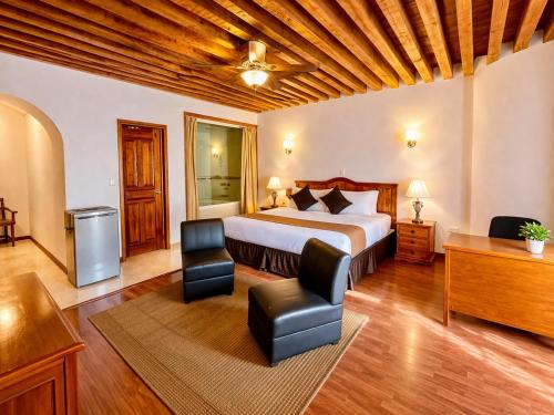 a bedroom with a bed and a desk and chair at Hotel Puebla Plaza in Puebla