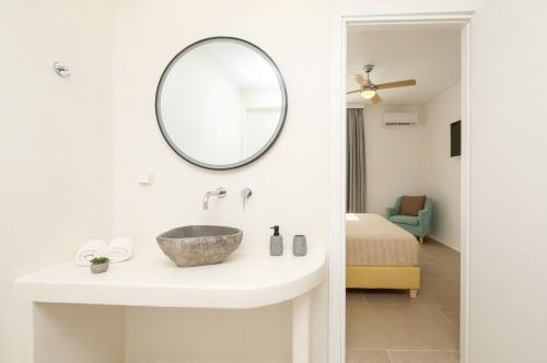 a bathroom with a sink and a mirror at Naxos Palace Hotel in Stelida