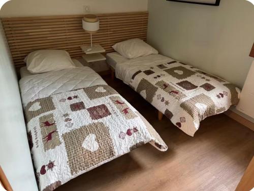 a bedroom with two beds with a quilt on it at Calm Waters in Doussard