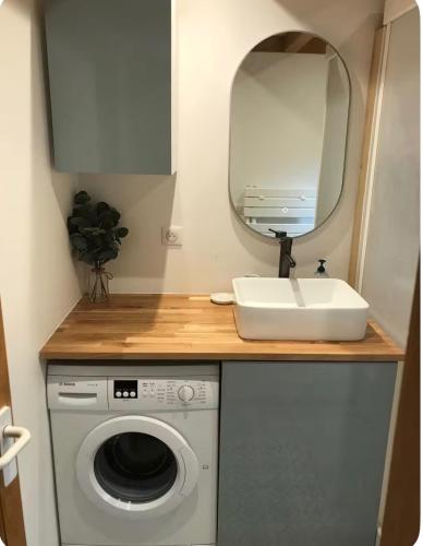 a bathroom with a sink and a washing machine at Calm Waters in Doussard
