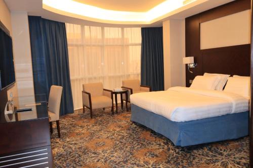 a hotel room with a bed and a table and chairs at Vercure Hotel فندق فيركيور جده الحمراء in Jeddah