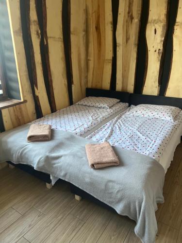 a bed with two towels on it in a room at uKazika in Orawka