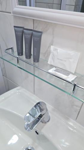 a glass shelf above a sink with two cups on it at Waverley Rest in Bloemfontein