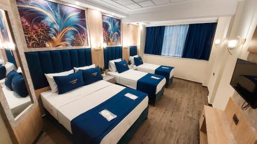 a hotel room with two beds and a television at Central Park Hotel İstanbul in Istanbul