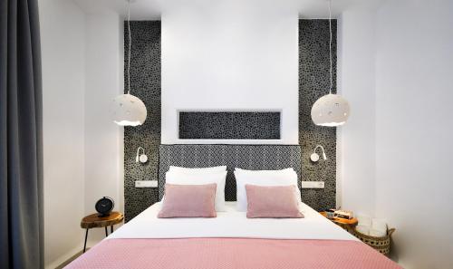 a bedroom with a pink bed with two pink pillows at Naxos Palace Hotel in Stelida