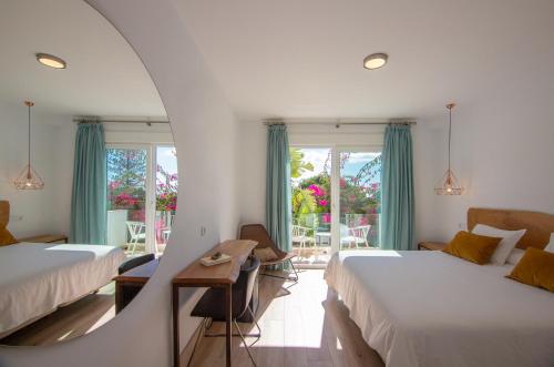 a hotel room with two beds and a mirror at Hotel Fortuna in Los Caños de Meca