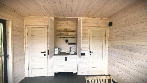 a room with two white doors and a kitchen at Лісове SPA in Vishenki