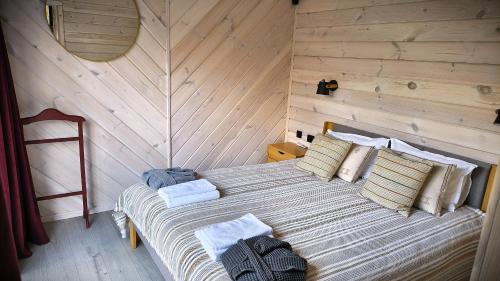 a bedroom with a bed with a wooden wall at Лісове SPA in Vishenki