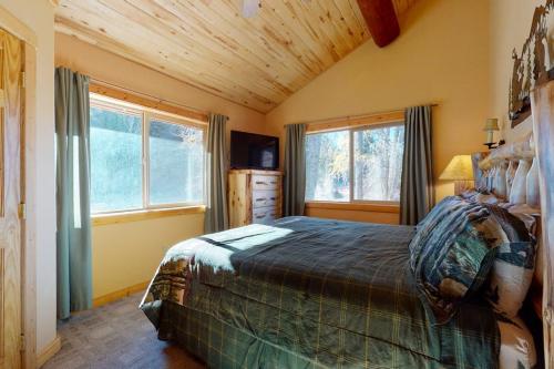 a bedroom with a bed in a room with windows at Rivercrest in South Fork