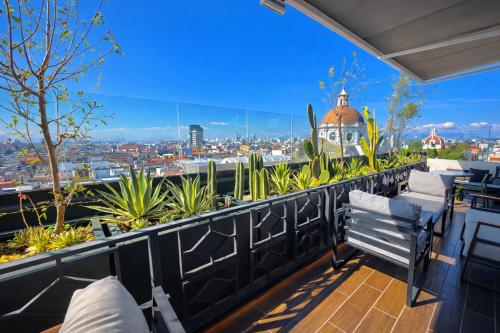 a balcony with chairs and a view of a city at Hotel Tamara in Puebla