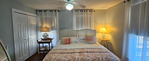 a bedroom with a bed and two lamps and a window at Barclay Cottage Inn in Virginia Beach