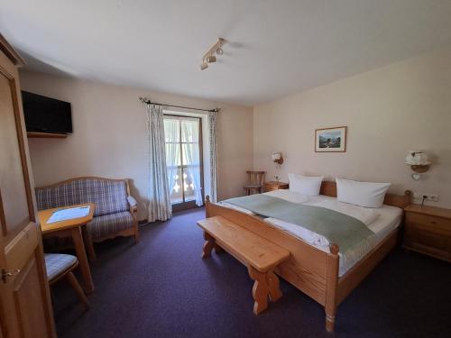 a bedroom with a large bed and a window at Zoberhof - Ferienhof zum Zoberbauer in Oberammergau