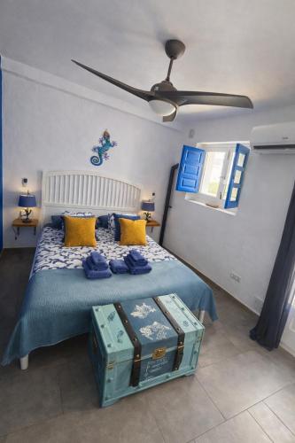 a bedroom with a bed with yellow and blue pillows at Casa mi sùeño azul in Torrox