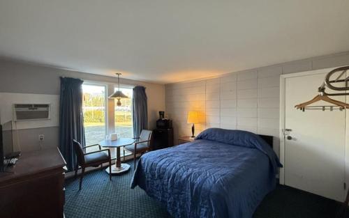 a hotel room with a bed and a table with chairs at Pineapple Inn in North Attleboro