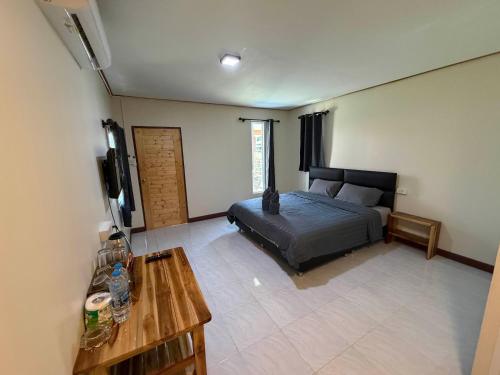 a bedroom with a bed and a table and a tv at NgopaKohKoodResort in Ban Bang Bao