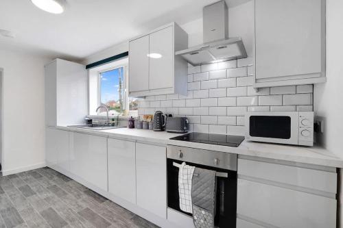 a white kitchen with a sink and a microwave at NEW! 3 Bedroom Home in Sunderland by Stay With Us, Perfect for Families & Contractors, FREE WiFi!! in Ryhope