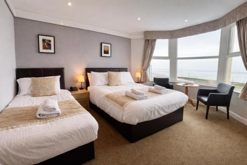 a hotel room with two beds and a window at The Auckland Hotel in Morecambe