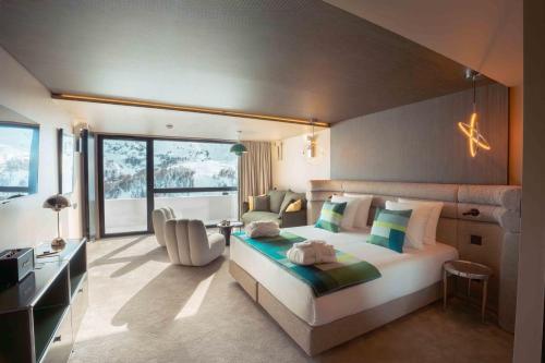 a bedroom with a bed and a desk and a chair at Fahrenheit Seven Les Menuires in Les Menuires