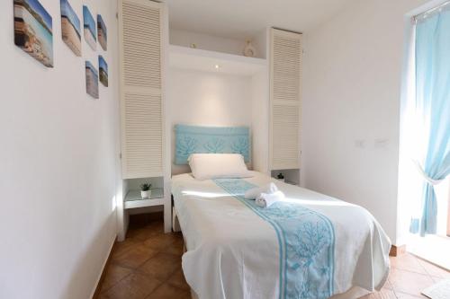 a bedroom with a bed with a blue head board at Ventimiglia Garden Suite in Olbia