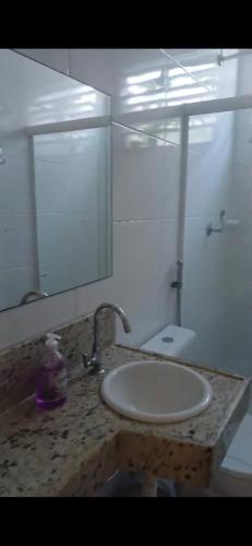 a bathroom with a sink and a mirror at Aconchego perto da praia in Aracaju