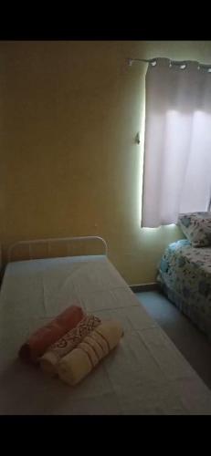 a bedroom with a bed with a towel on it at Aconchego perto da praia in Aracaju