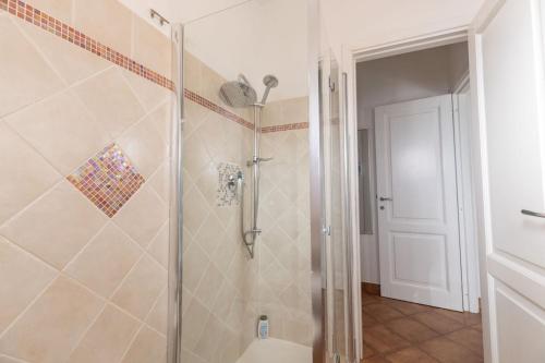 a shower with a glass door in a bathroom at Ventimiglia Garden Suite in Olbia