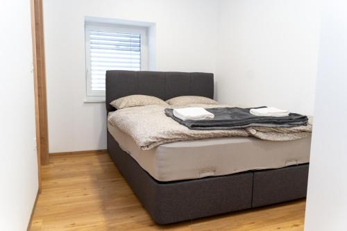 a bed with a black headboard in a room at Edi Residence in Oplotnica