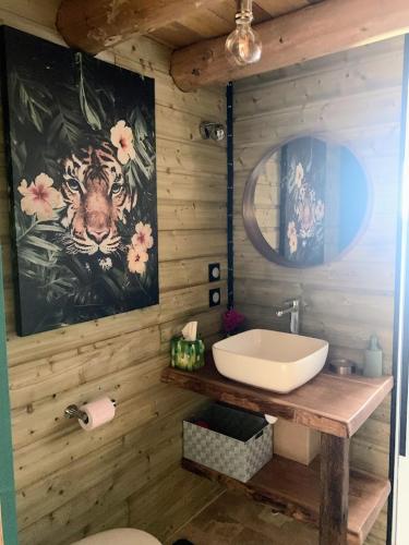 a bathroom with a sink and a painting of a tiger at Le Garage in Lamotte-Beuvron