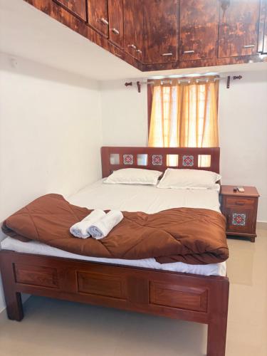 a bed with two towels on it in a bedroom at Rainbow721 in Pondicherry