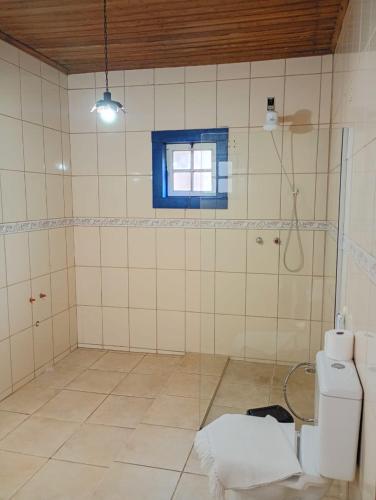 a bathroom with a toilet and a window at Pousada Arco íris na Serra in Tiradentes