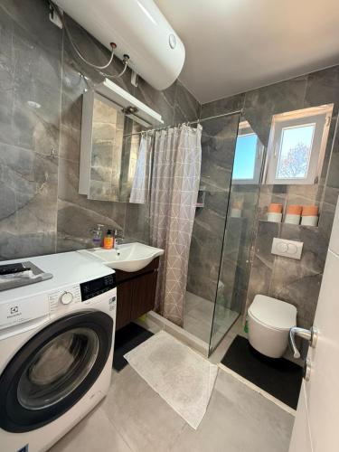 ein Badezimmer mit Waschmaschine und Dusche in der Unterkunft Manya in Seoca