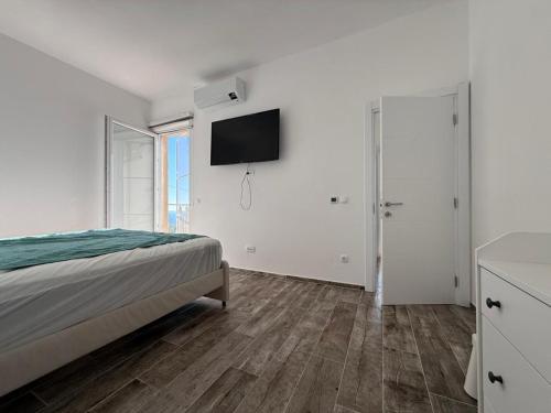 ein Schlafzimmer mit einem Bett und einem Fernseher an der Wand in der Unterkunft Manya in Seoca