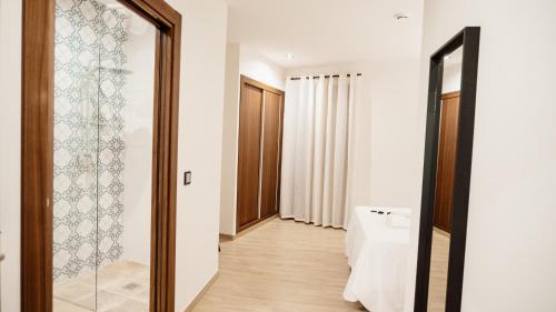 a bathroom with a glass door leading to a hallway at Hostal Central Marmolejo in Marmolejo