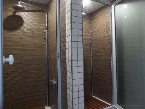 a walk in shower with a glass door in a bathroom at Elegance Hotel Tandil in Tandil