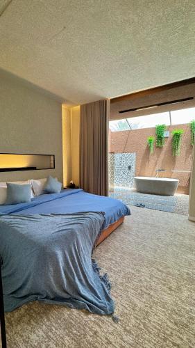 a bedroom with a large bed and a large window at هدوء المنتهى in Al Munayzilah