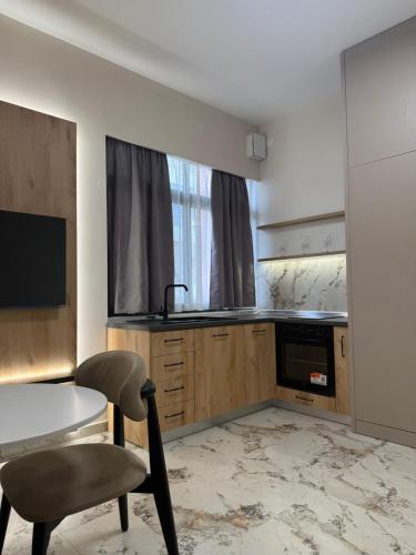 a kitchen with a table and a chair in a room at Selez Aparthotel & Residence in Durrës
