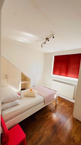 a bedroom with a bed with a red window at Broadway Apartment in London