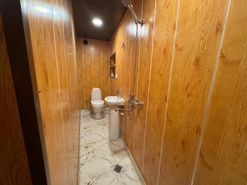 a bathroom with a toilet and wooden walls at Nato & Lado in Sighnaghi