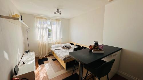 a small room with a bed and a desk in it at Broadway Apartment in London