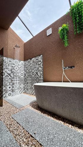a bathroom with a bath tub next to a wall at هدوء المنتهى in Al Munayzilah