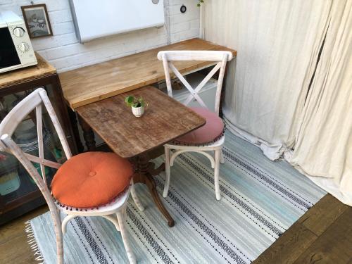a small table with two chairs and a table with a plant on it at Cosy hideaway with garden sauna in Cambridge in Cambridge