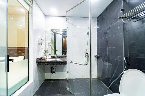 a bathroom with a glass shower and a toilet at Khách Sạn Melanta - FLC Sầm Sơn in Sầm Sơn