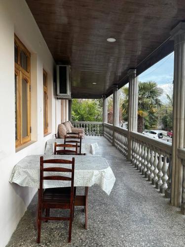 a balcony with two chairs and a table on a porch at Tskaltubo Guesthouse Oda in Tsqaltubo