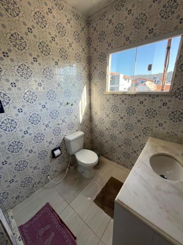a bathroom with a toilet and a sink at Santorini Flats in Arraial do Cabo