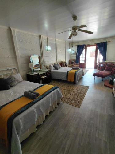 a bedroom with three beds and a ceiling fan at Uncle Charlie in Kroonstad