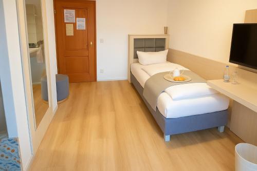 a hotel room with a bed and a television at Budget Messehotel by Daucher in Nuremberg