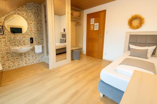 a bedroom with a bed and a bathroom with a sink at Budget Messehotel by Daucher in Nuremberg